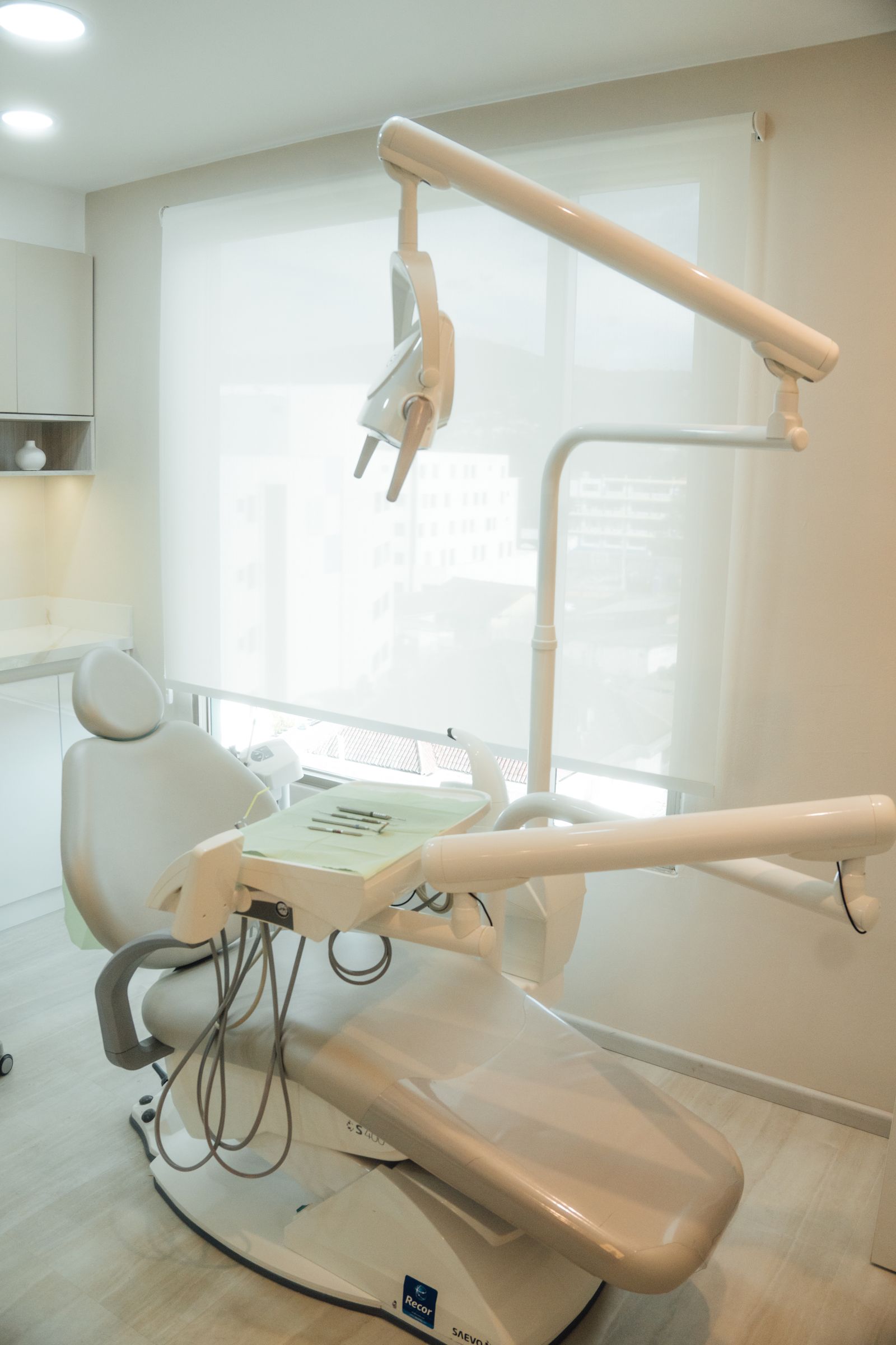 Warm, naturally lit dental treatment room with a single chair